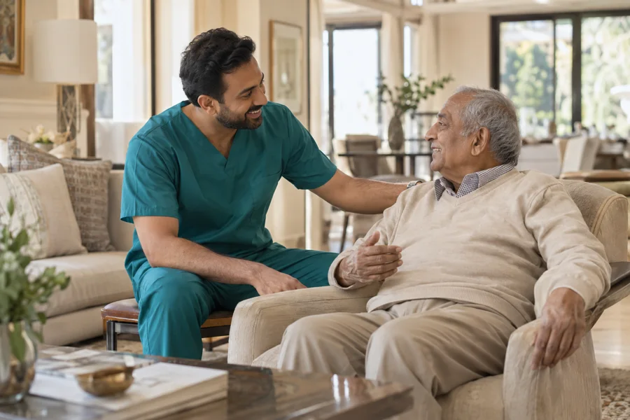 A male caregiver and an older gentleman enjoying a conversation at home